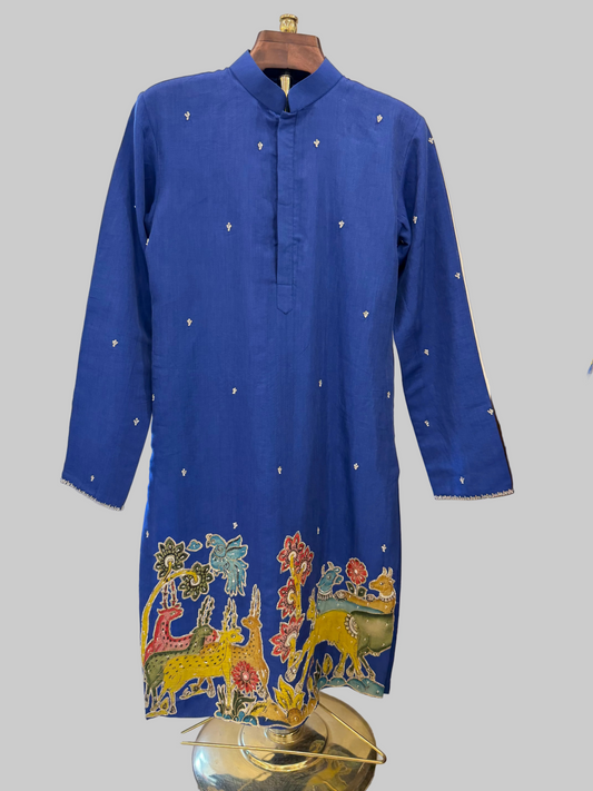 Blue kurta with colorful embroidery on a hanger against a neutral wall.